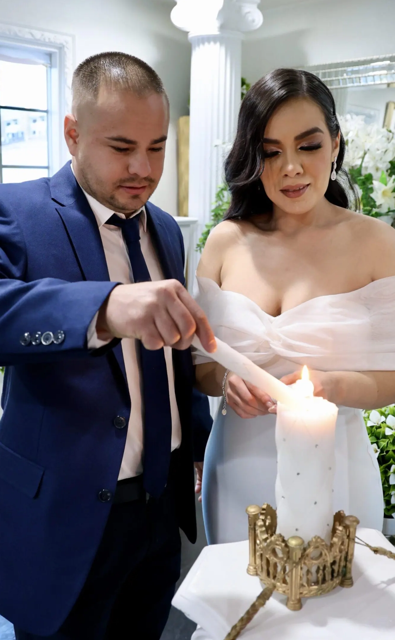 Couple lighting a candle together at a ceremony.
