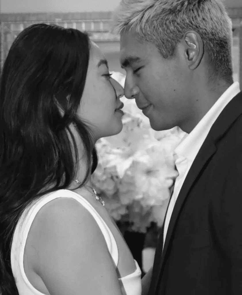A couple shares an intimate, close moment with foreheads touching.
