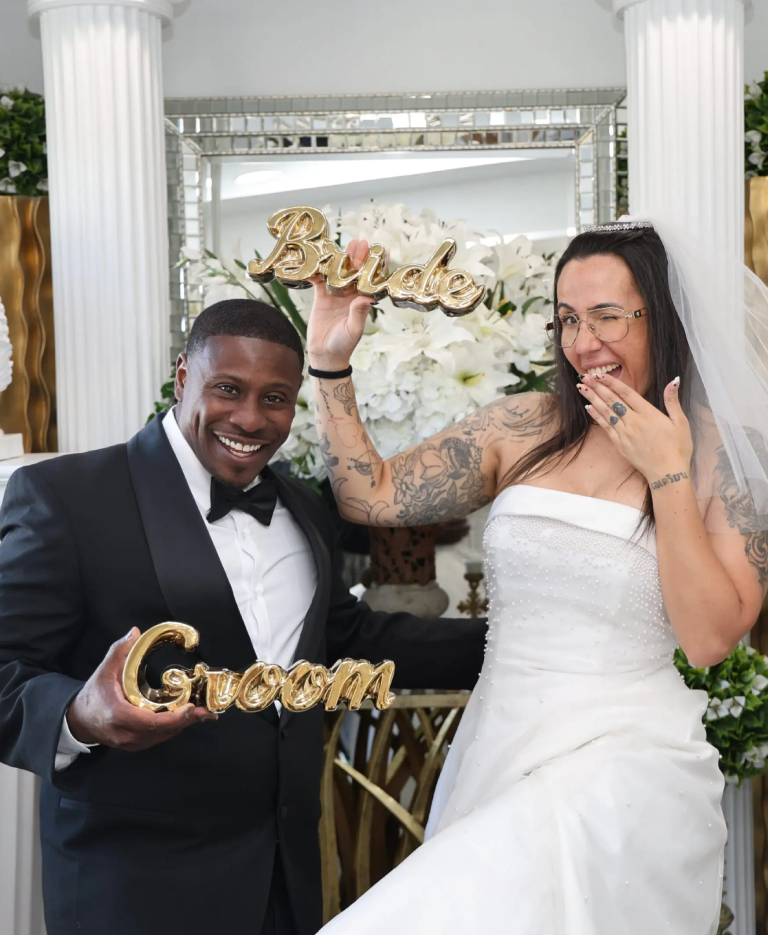 Happy newlyweds celebrating with groom and bride signs.